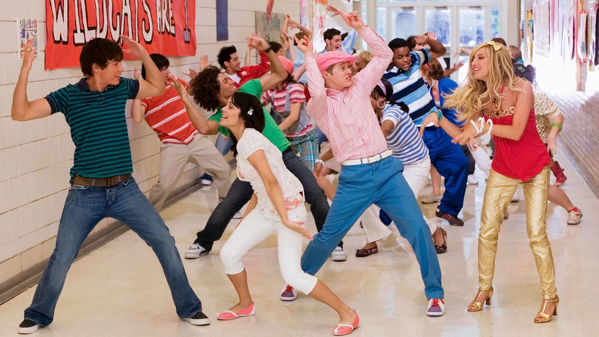 The cast of High School Musical 2 dancing in the school corridors