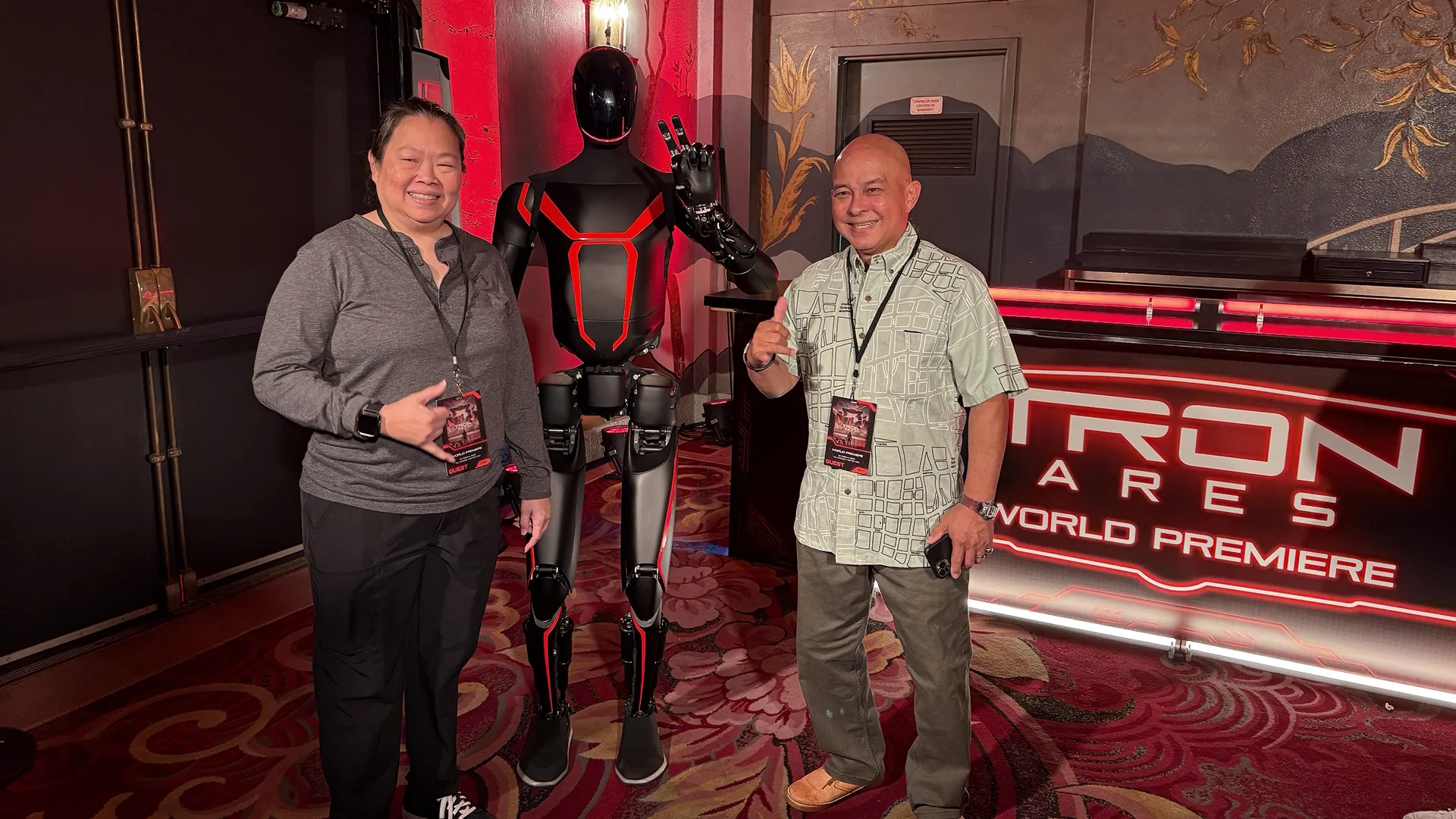 Jeanine C. and her husband pose with a black and white humanoid robot.