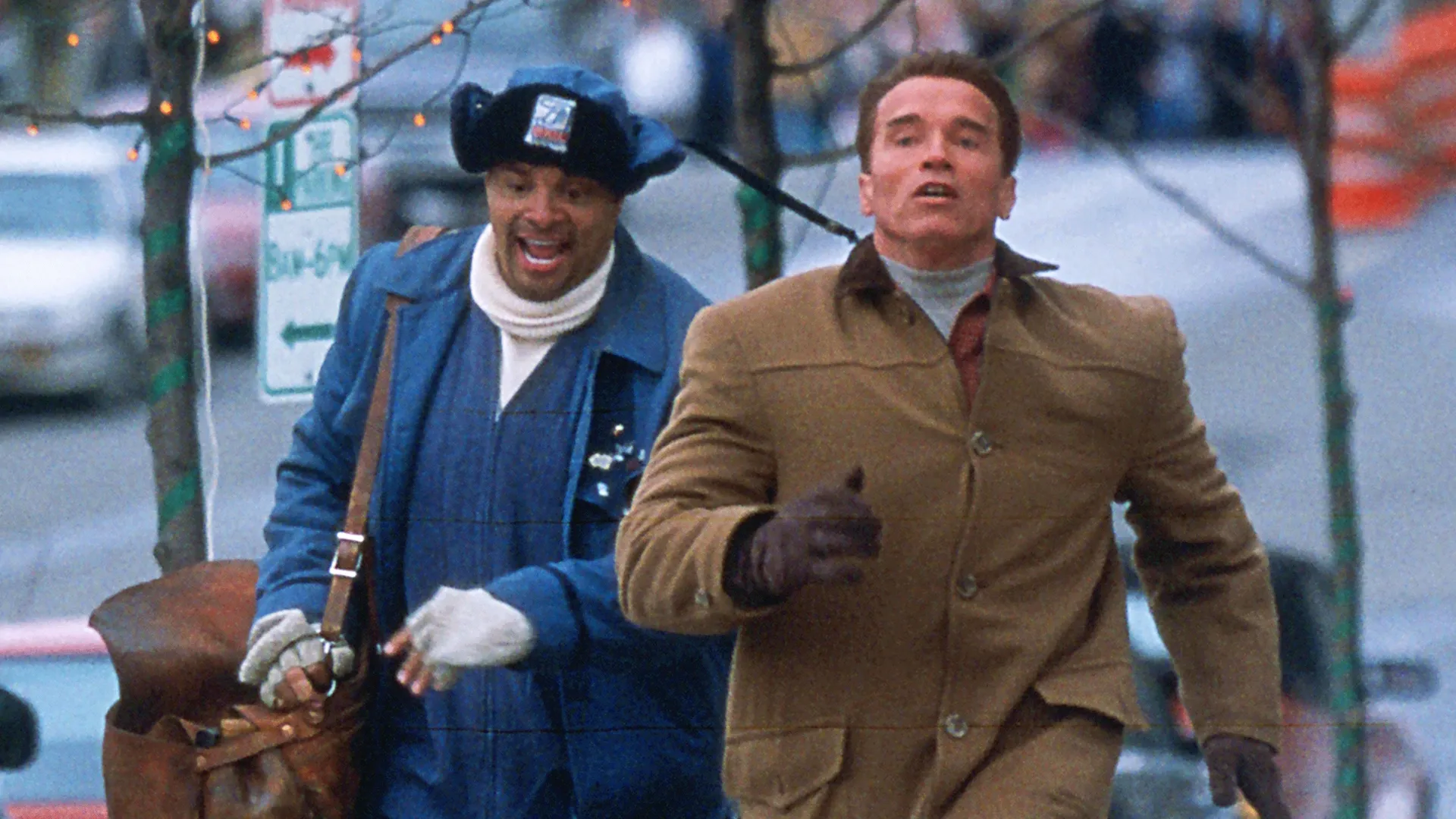 Myron Larabee (Sinbad) and Howard Langston (Arnold Schwarzenegger) run down a street.