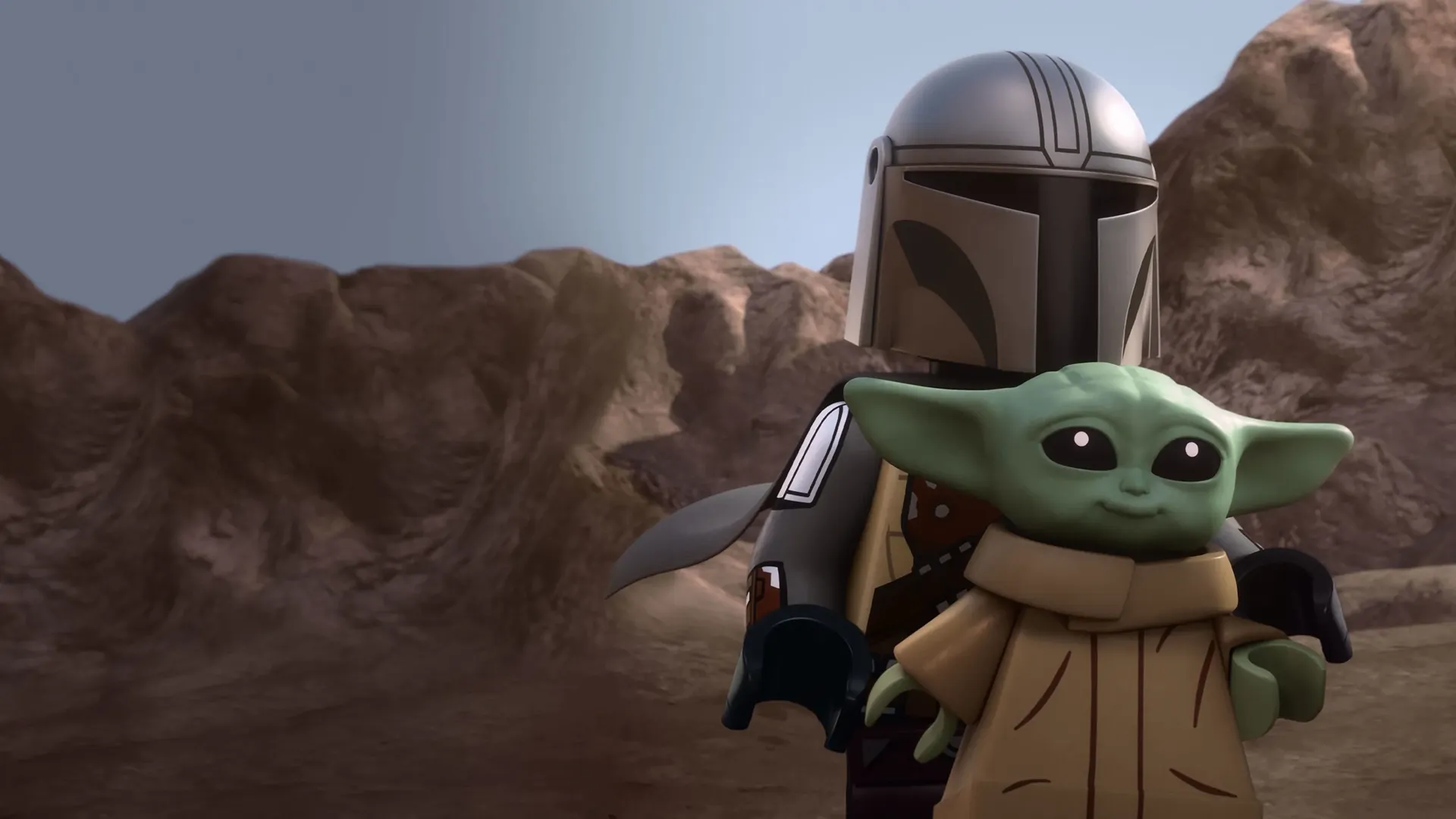 LEGO version of the Mandalorian holding a small Grogu figure in front of a rocky, brown desert landscape from a Star Wars animated project.