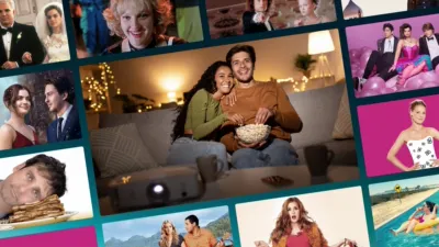 A collage of colorful movie posters and film stills surrounding a central photo of a smiling couple sitting on a couch, eating popcorn, and watching a movie using a home projector. The surrounding tiles feature scenes from various romantic comedies and dramas, including The Hating Game starring Lucy Hale and Robbie Amell, the Jennifer Lawrence comedy No Hard Feelings, Adam Sandler and Drew Barrymore in 50 First Dates, and Isla Fisher in Confessions of a Shopaholic.