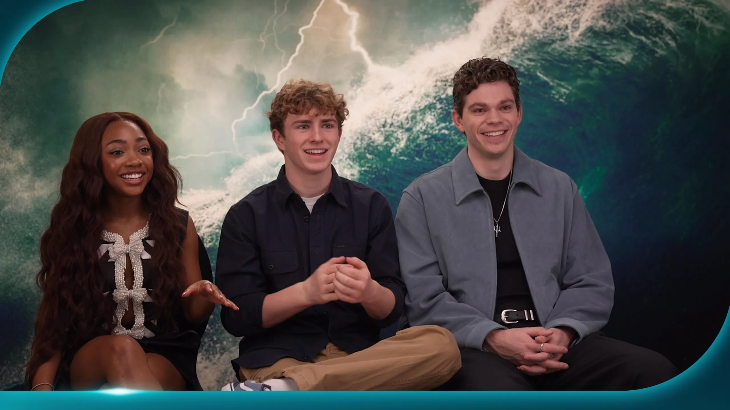 Percy Jackson and The Olympians cast members Leah Jeffries, Walker Scobell, and Daniel Diemer sat for an interview, with an ocean waves background