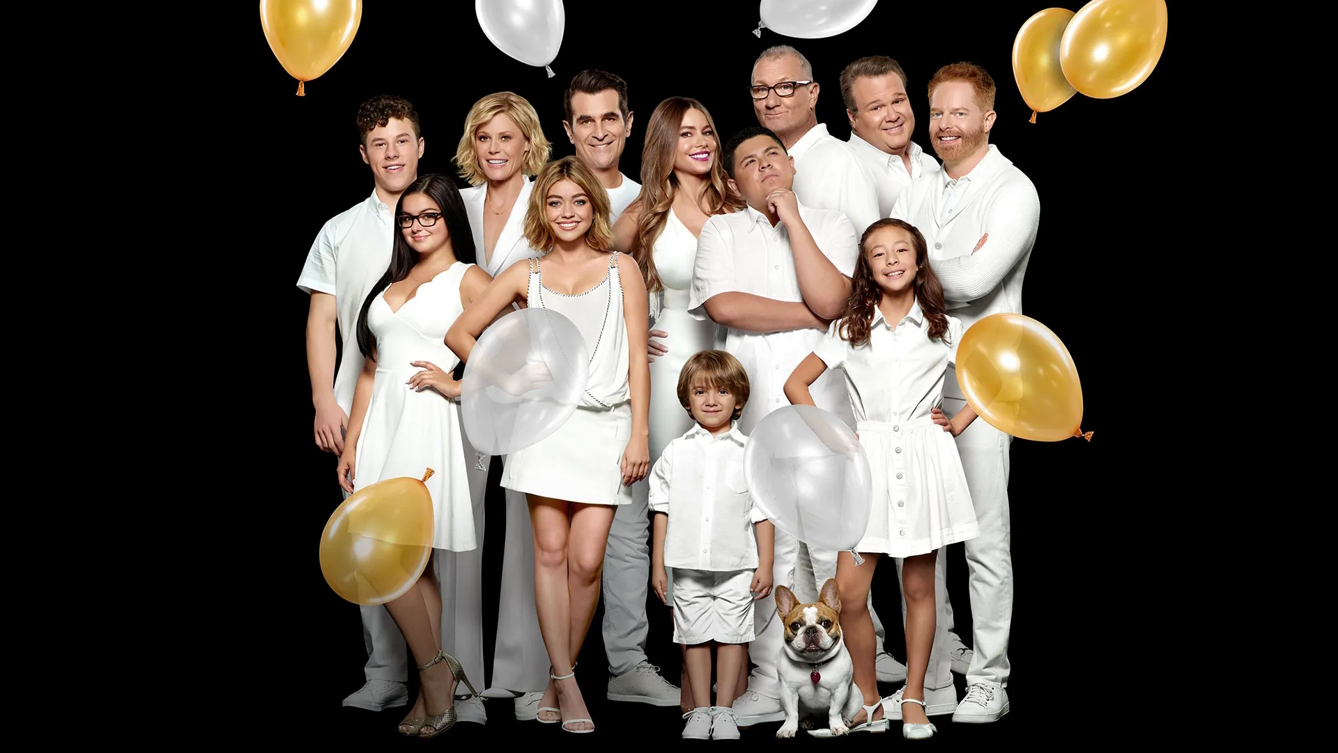 Key art for Modern Family featuring the extended family gathered together in white outfits with gold and silver balloons surrounding them.