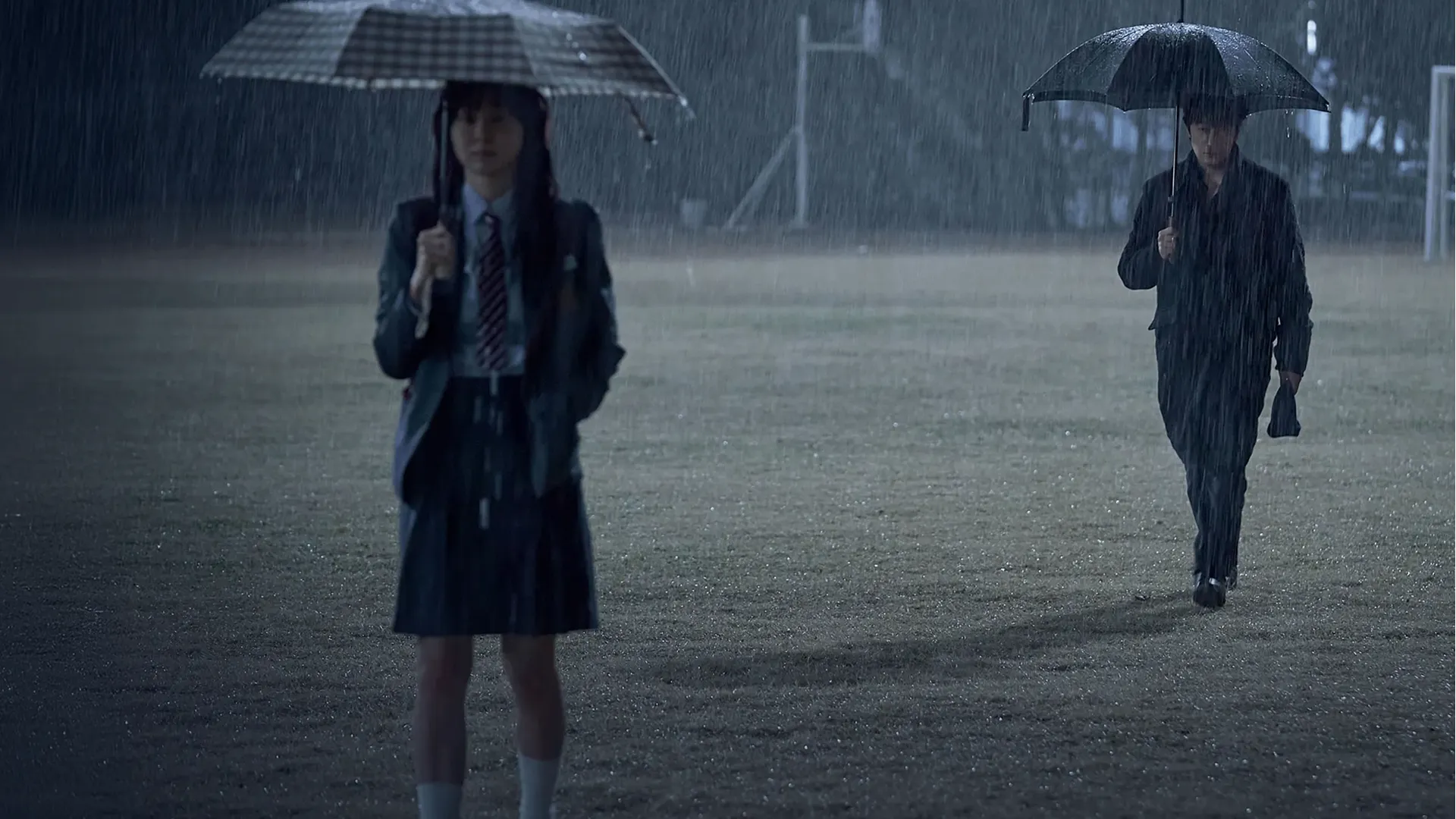 Main characters of Nine Puzzles standing in the rain on a sports field.