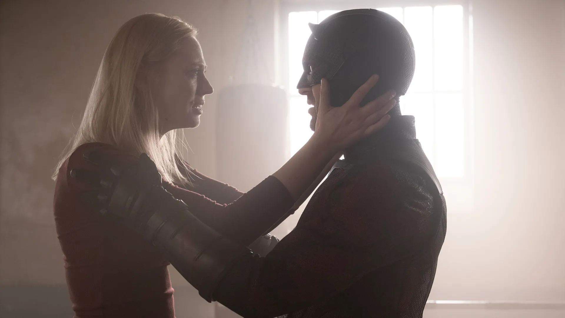Karen Page (Deborah Ann-Woll) and Daredevil a.k.a Matt Murdock (Charlie Cox) embrace each other.