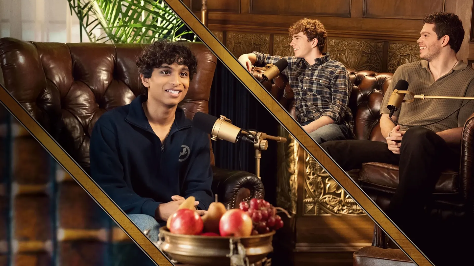Percy Jackson and the Olympians Podcast host Aryan Simhadri (who plays Grover in the show) sitting in a large leather chair with a microphone with fellow cast mates Walker Scobell (Percy Jackson) and Daniel Diemer (Tyson).