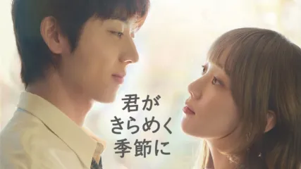 『君がきらめく季節に』のプロモーション画像。柔らかな光に包まれた背景の中、2人が向かい合うように見つめ合い、中央に作品タイトルが表示されている。夏のように明るい人物と冬のように心を閉ざした人物が出会い、互いを理解しながら心を癒していくハートフル・ラブロマンス作品。