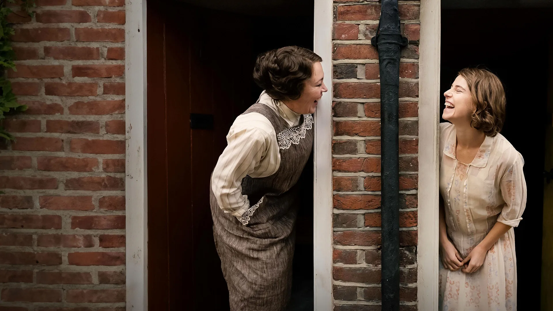 Edith Swan (Olivia Colman) laughs with her neighbor Rose Gooding (Jessie Buckley) whom she accuses of sending foul-mouthed letters.