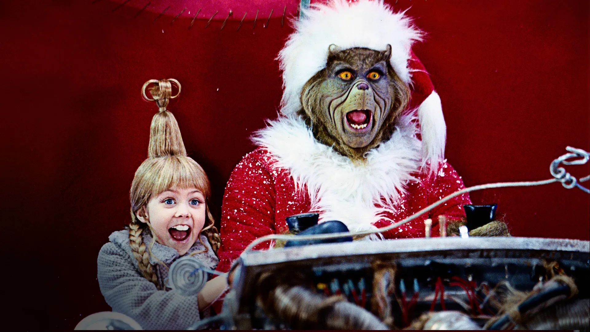 A gleeful Cindy Lou Who (Taylor Momsen) and Grinch (Jim Carrey) sit in Santa's sleigh.