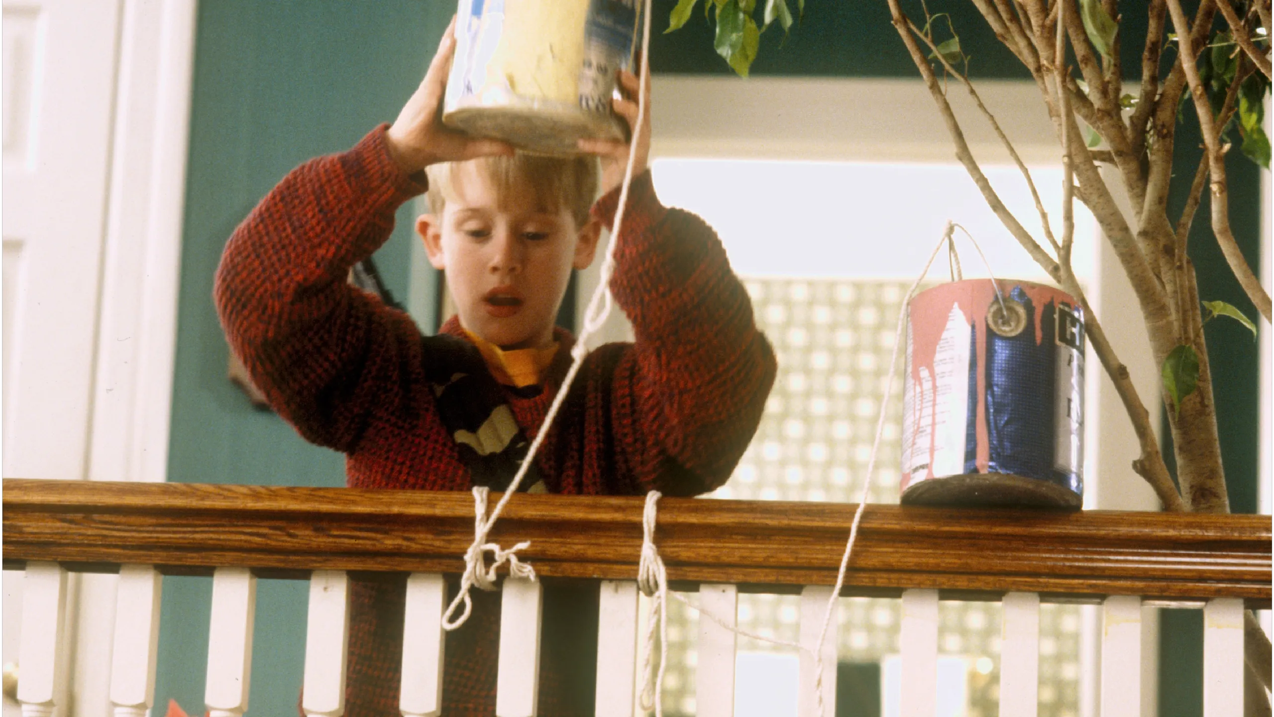 Kevin McCallister (Macauley Culkin) preparing to a throw a pot of paint at the bandits from the top of the stairs.