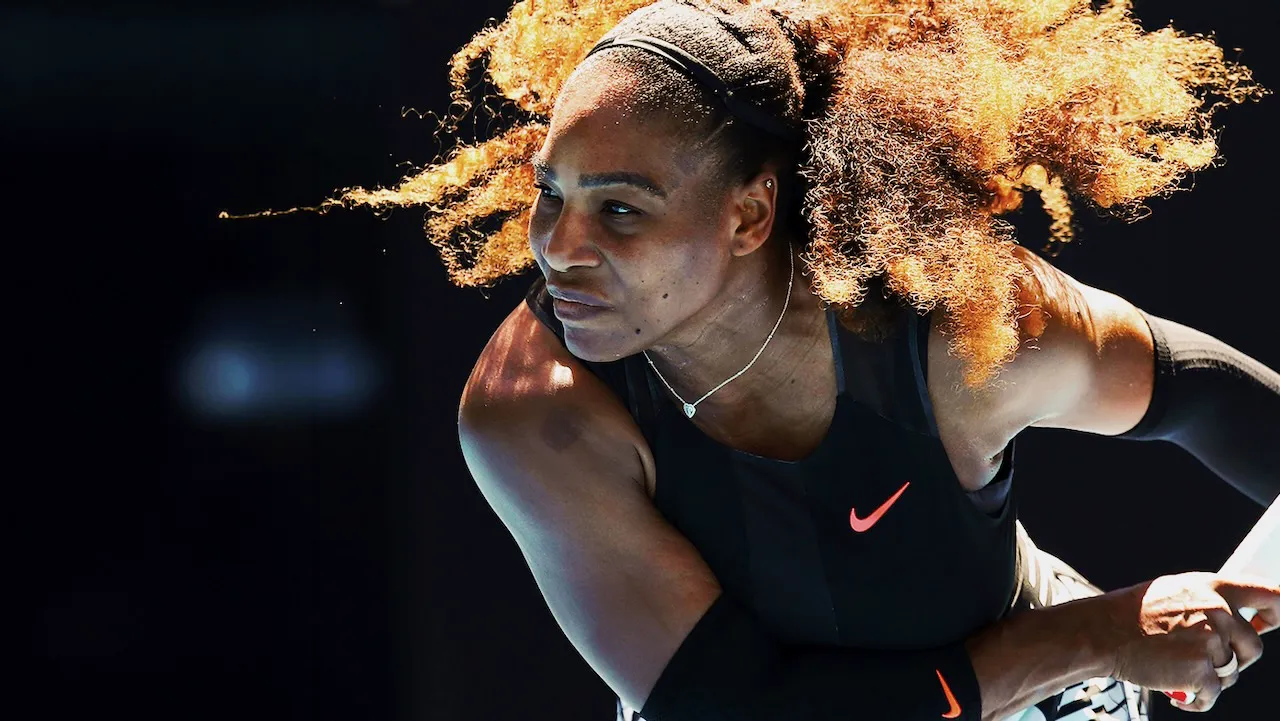 Professional tennis player prepares to serve during a competitive match.