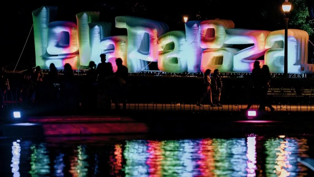 Image of inflatable letters spelling “Lollapalooza” reflected in water at the festival in Chicago, Illinois.