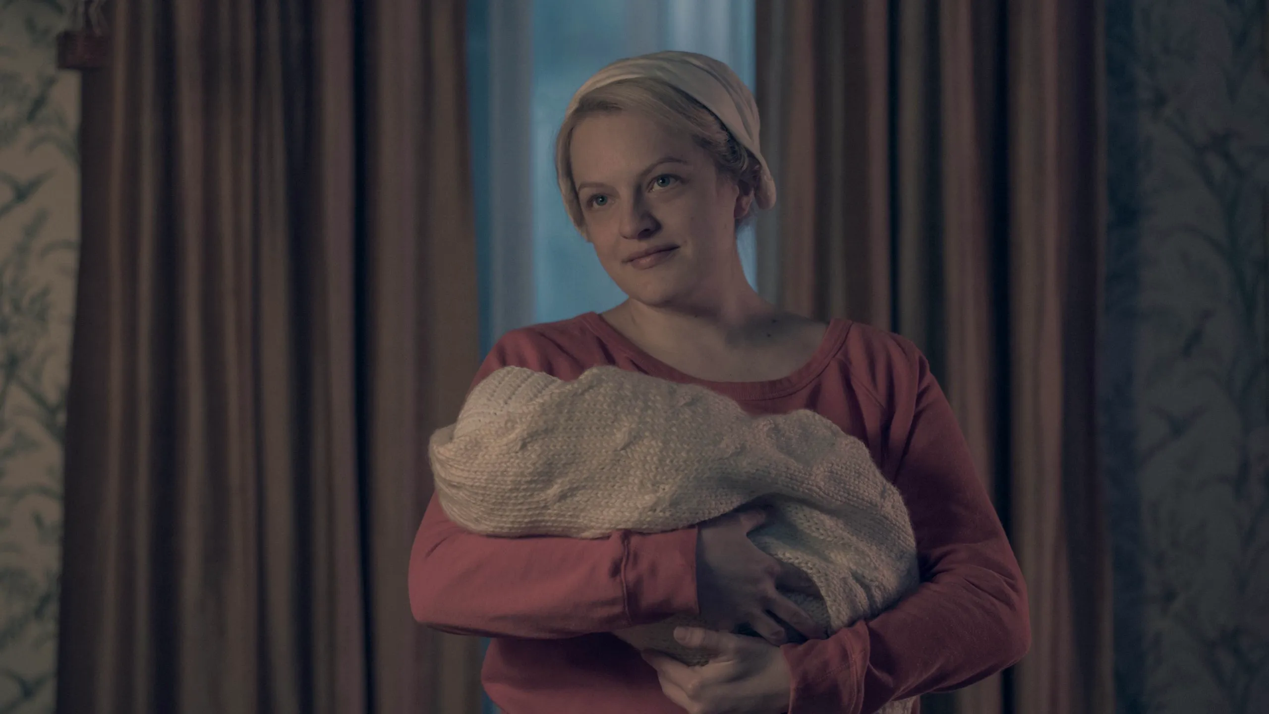 June (Elisabeth Moss) swaddling baby Nichole in The Handmaid’s Tale.