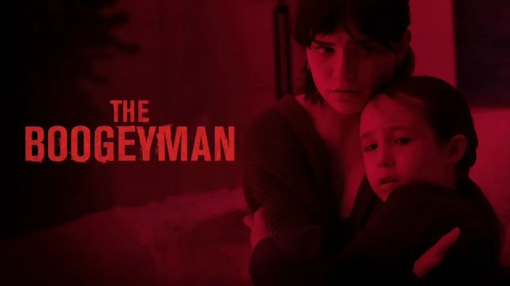 Poster for The Boogeyman showing a young woman holding and protecting a frightened girl in a dimly lit red room, with the movie title in bold red text on the left.