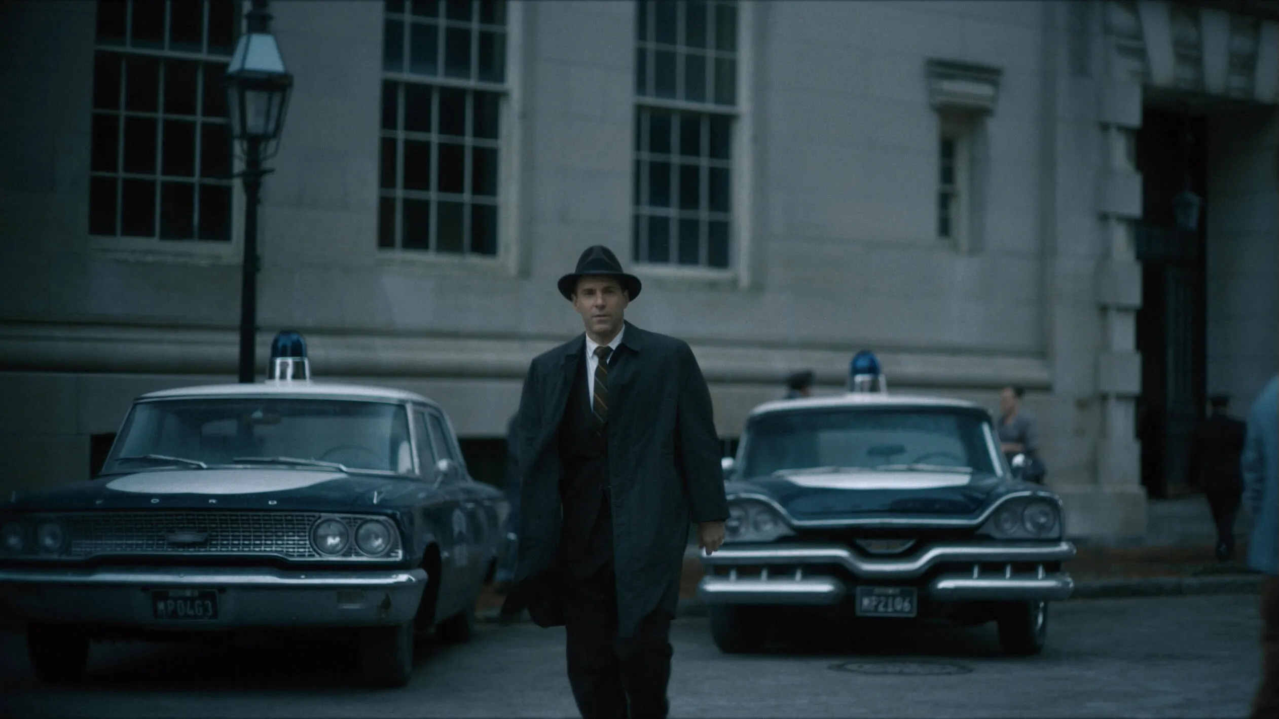 A man in a trench coat and fedora in a scene from the movie Boston Strangler.