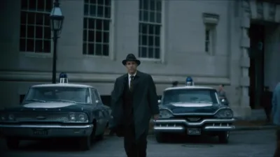 A man in a trench coat and fedora in a scene from the movie Boston Strangler.