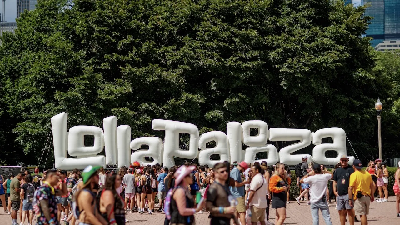 Fans walk through Grant Park past the large Lollapalooza sign during the annual Chicago music festival.
