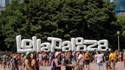 Fans walk through Grant Park past the large Lollapalooza sign during the annual Chicago music festival.