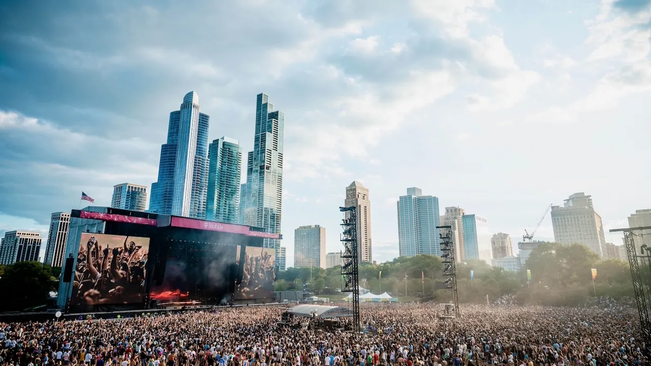 A massive crowd gathers around a stage with the Chicago skyline in the background.
