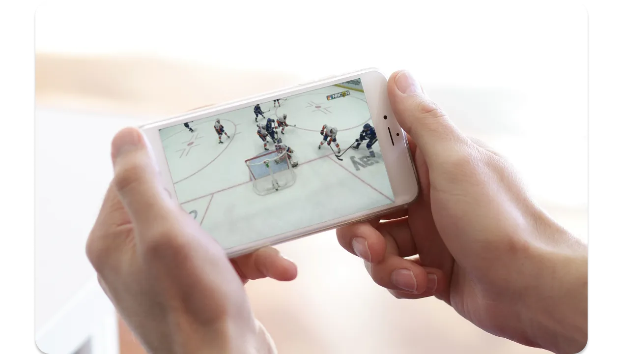 Person watching college football on a smartphone.