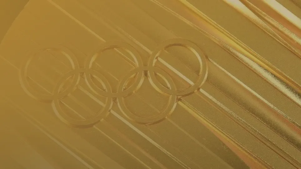 Close-up of an Olympic gold medal with embossed Olympic rings.