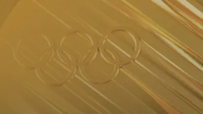 Close-up of an Olympic gold medal with embossed Olympic rings.