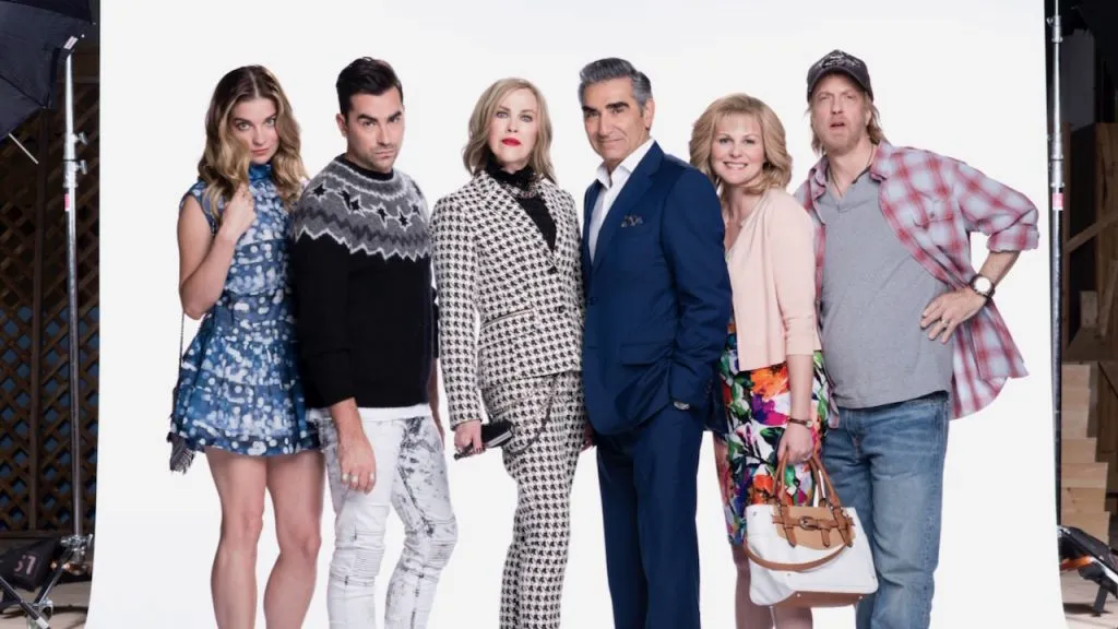 The main cast of Schitt’s Creek posing in front of a white backdrop.