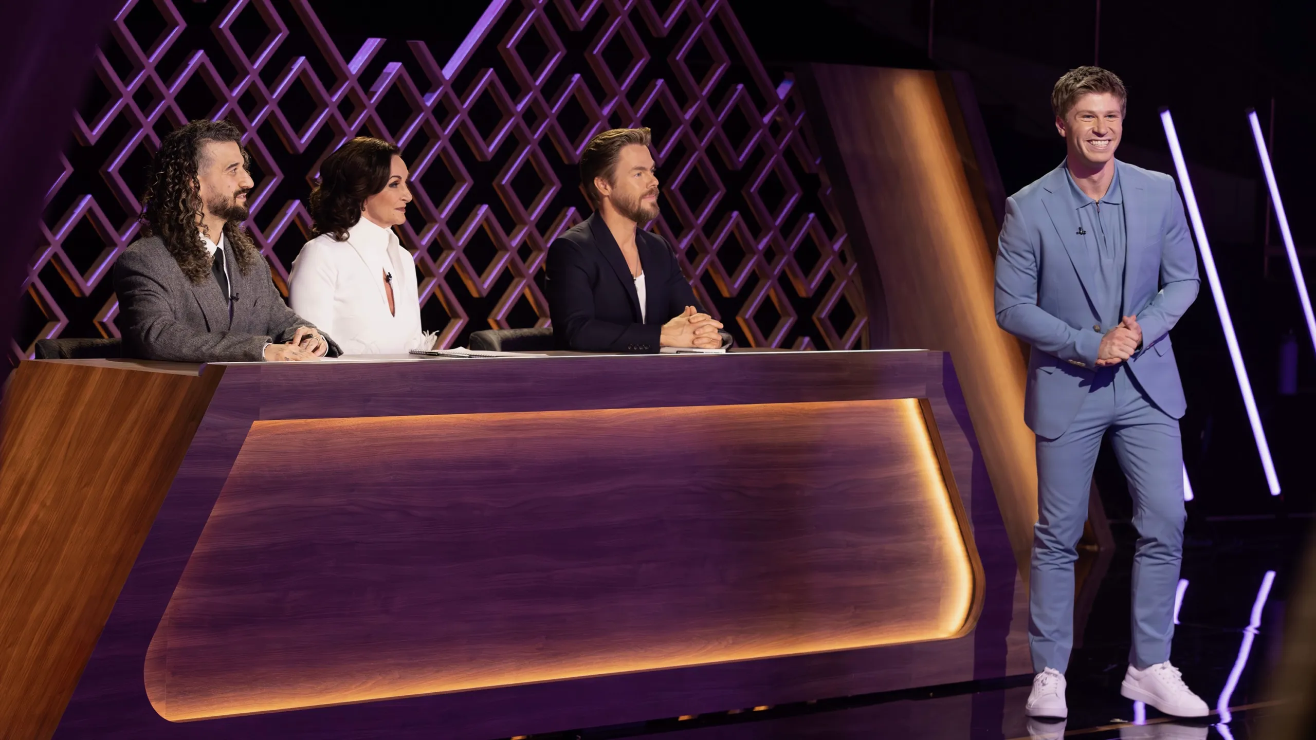 Host Robert Irwin stands beside the judges’ table in a still of Dancing With the Stars: The Next Pro.