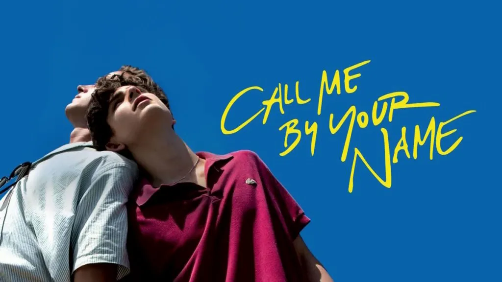 Title art for Call Me By Your Name featuring two young men leaning back against each other under a clear blue sky.