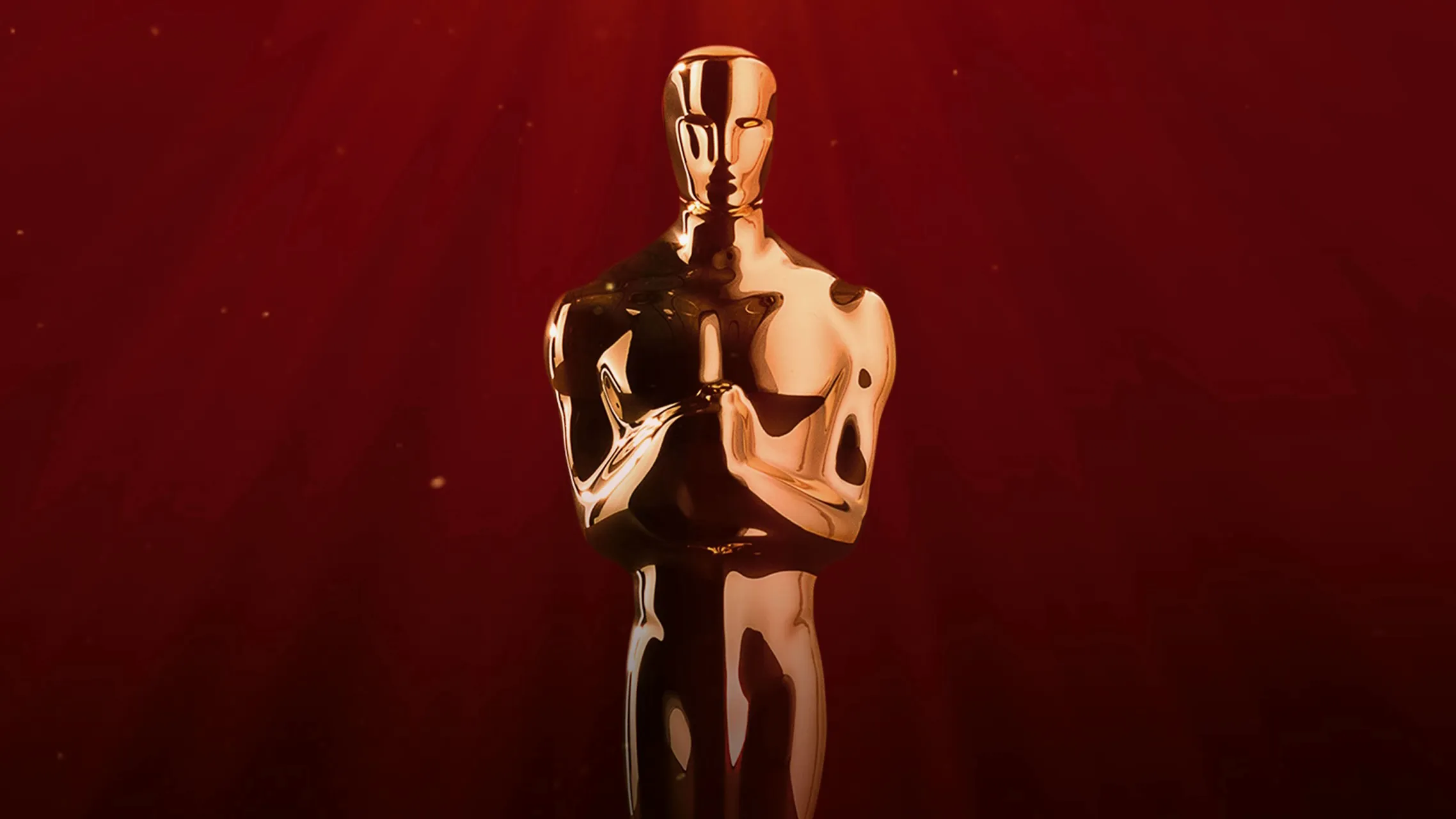 A gold Oscar statuette centered against a rich red background.