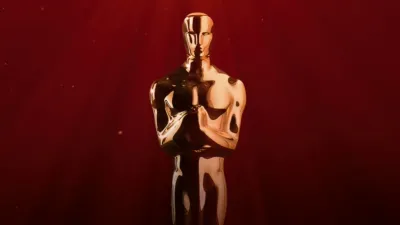 A gold Oscar statuette centered against a rich red background.
